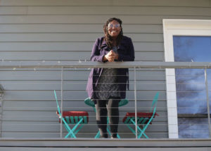Jhanev Allen Butler stands on her balcony at Sheridan Small Homes. Photo by Jonathan Wiggs/The Boston Globe