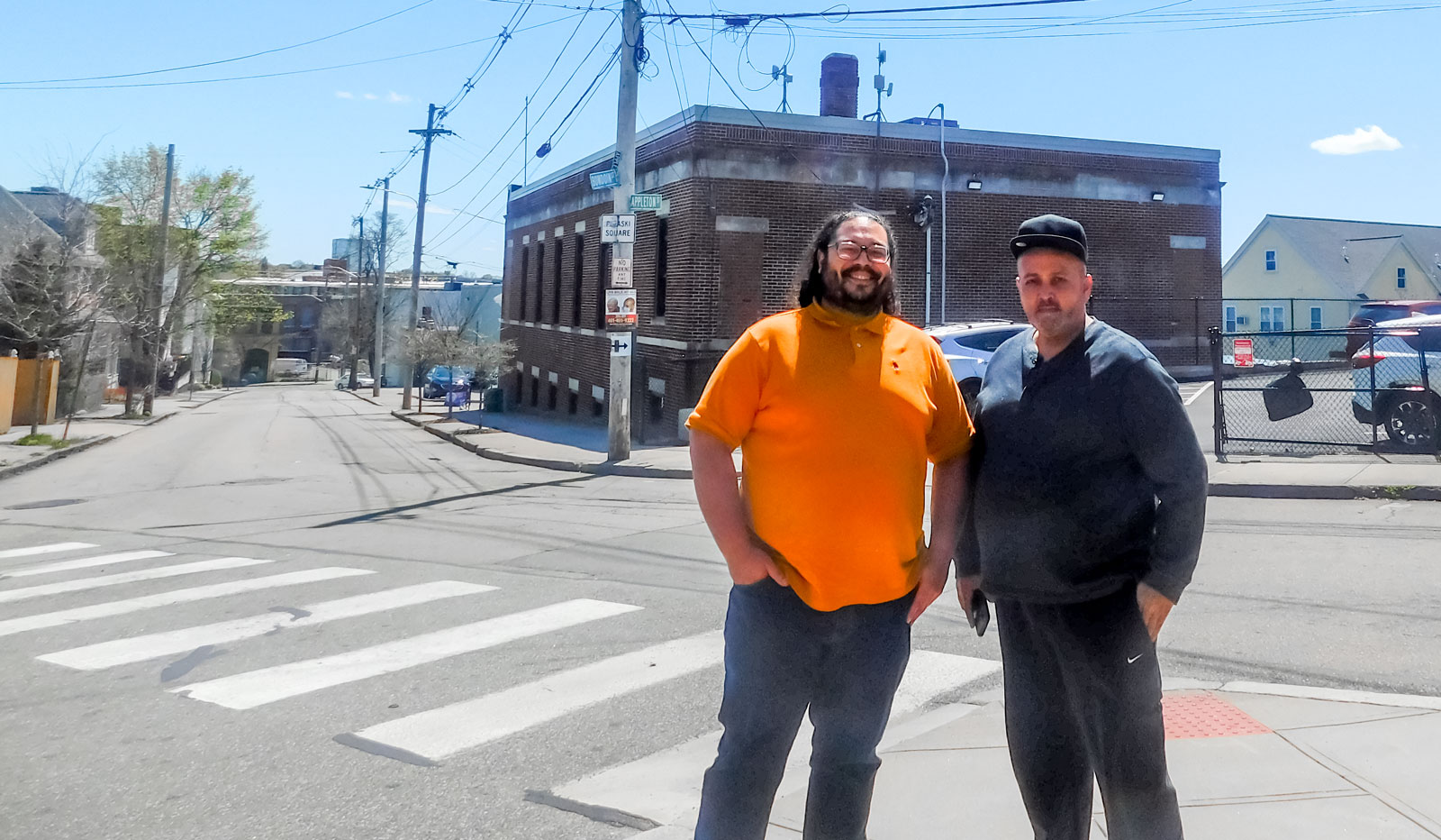 Antonio Rodriguez, ONE|NB’s Assistant Director of Asset Management, left, and Harry Quiñones, of Providence, stand outside ONE Neighborhood Builders' office on Chaffee Street, where one of the ONE|NB Connects WiFi transmitters is located.