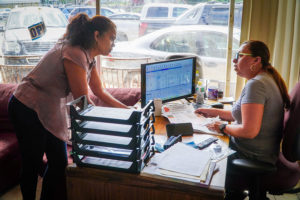 Clara Diaz speaks with Maria Caceres at Techno Car Auto Sales and Service, 433 Hartford Ave., Providence, about the Central Providence Loan Fund.