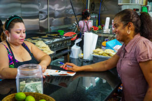 At Tortilleria El Quetzal, Hartford Ave., Providence, Clara Diaz leaves information about the Central Providence Loan Fund after speaking with Yessica Orellana.