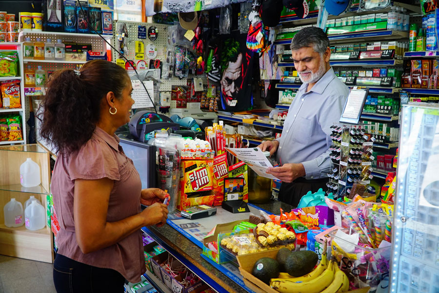 Clara Diaz speaks with Zahid Butt, a clerk at Lane's, a convenience store on Hartford Ave.
