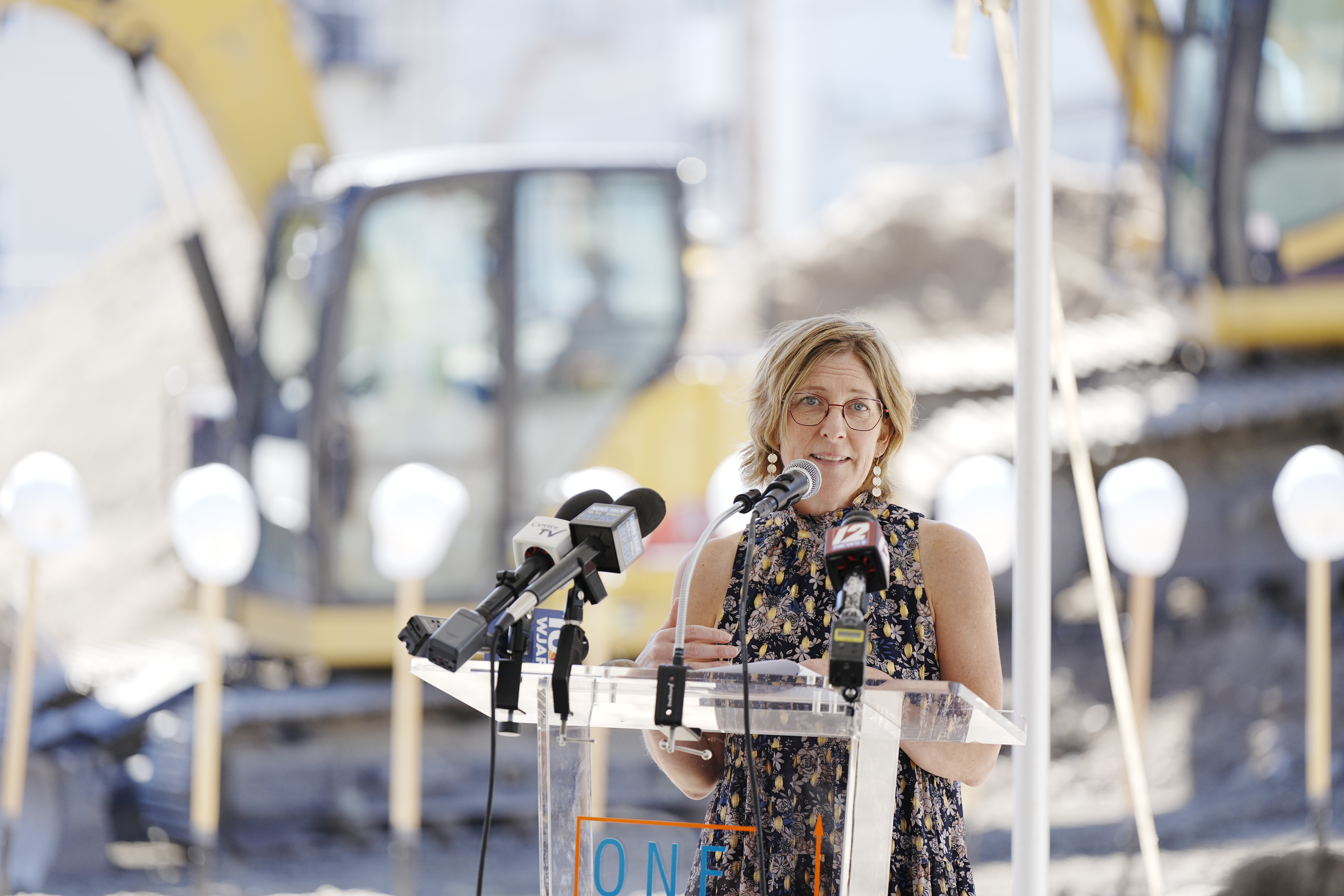 A presidente e CEO da ONE Neighborhood Builders, Jennifer Hawkins, dirige-se aos participantes da inauguração do The Avenue's 28 de junho de 2024